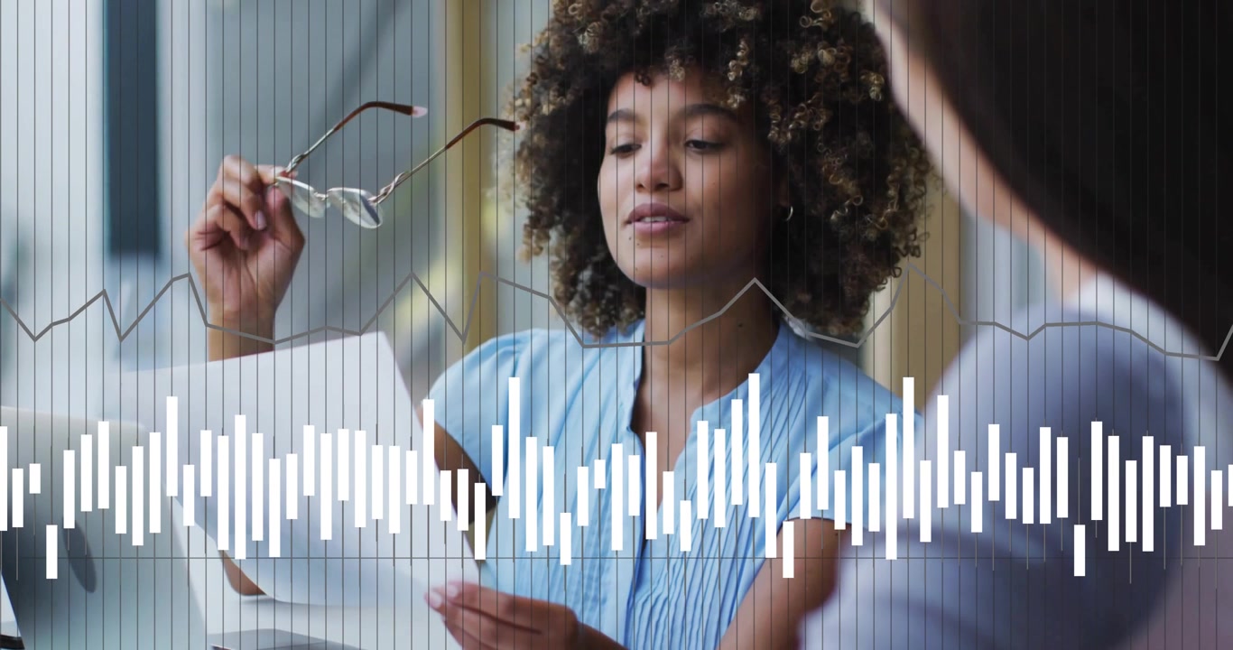 Animation of data processing and diagrams over diverse businesswomen discussing work in office