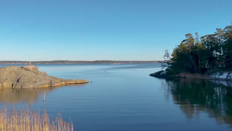 serene water of baltic sea on swedish east coast with trees and barren rock, stockholm archipelago