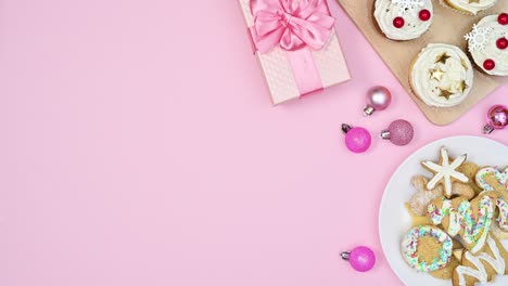 arreglo de navidad con galletas de pan de jengibre y pasteles se mueven en tema rosa pastel.