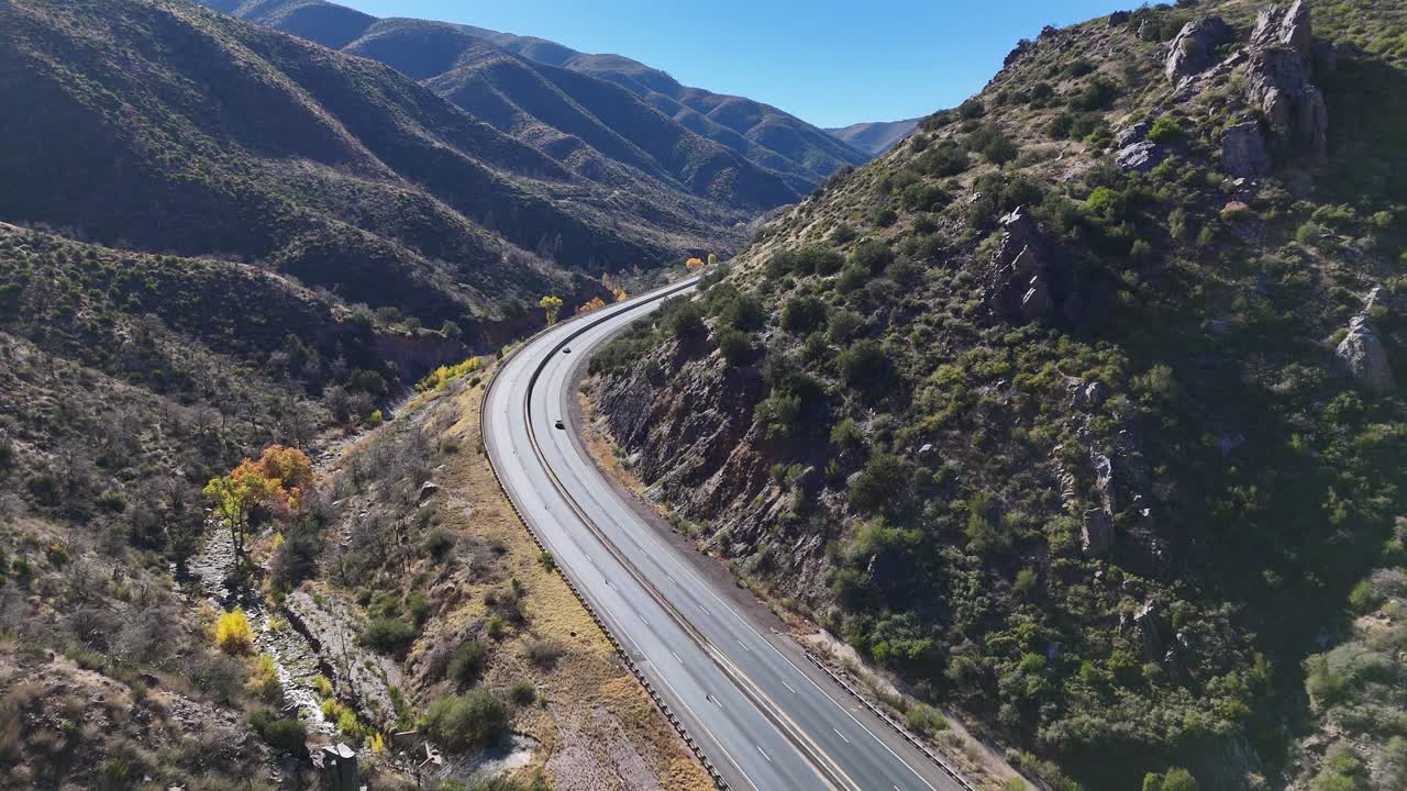 drone volando sobre una carretera curva entre las montañas