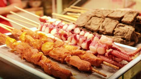 una variedad de salchichas expuestas en un puesto de comida callejera