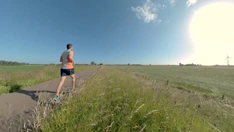 swirling immersive camera movement changing angles and perspective showing a male trail runner on floodplains valley dyke