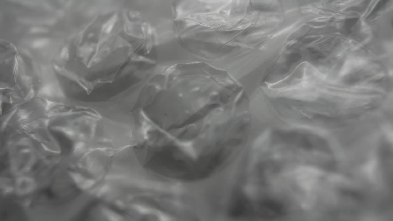 Primer plano de textura abstracta de plástico de burbujas transparente. Enfoque suave, aspecto monocromático, fondo minimalista de material de embalaje con sutiles reflejos de luz.