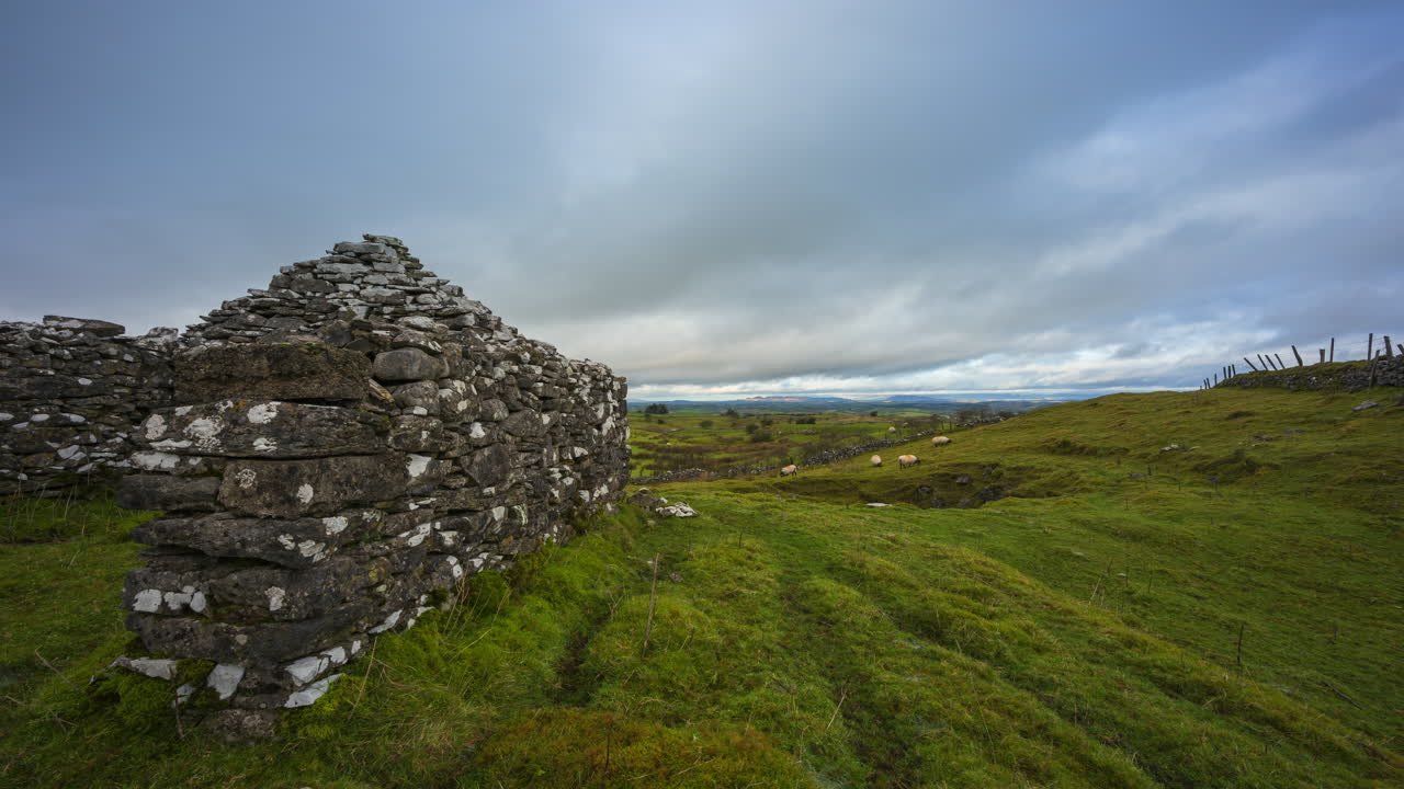 timelapse de tierras de cultivo de naturaleza rural con muro de piedra y ovejas de campo en primer plano durante el día nublado visto desde carrowkeel en el condado de sligo en irlanda