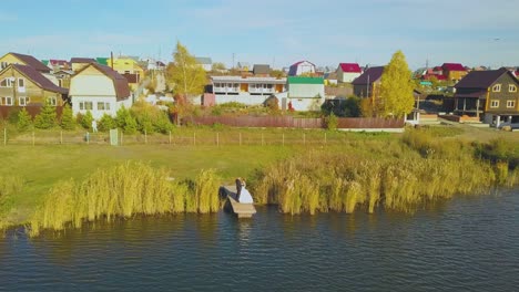 Una-Pareja-De-Recién-Casados-Se-Abraza-En-El-Muelle-Cerca-De-La-Vista-Superior-Del-Gran-Río