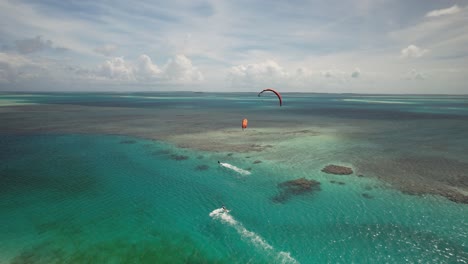 Kitesurfistas-Deslizándose-Sobre-Aguas-Cristalinas-En-Cayo-Vapor-En-Los-Roques,-Vista-Aérea