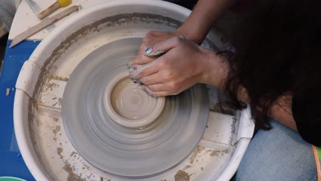 young woman in pottery studio using pottery wheel, handmade ceramics, creative