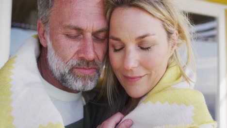 feliz caucásica pareja madura envuelta en la manta