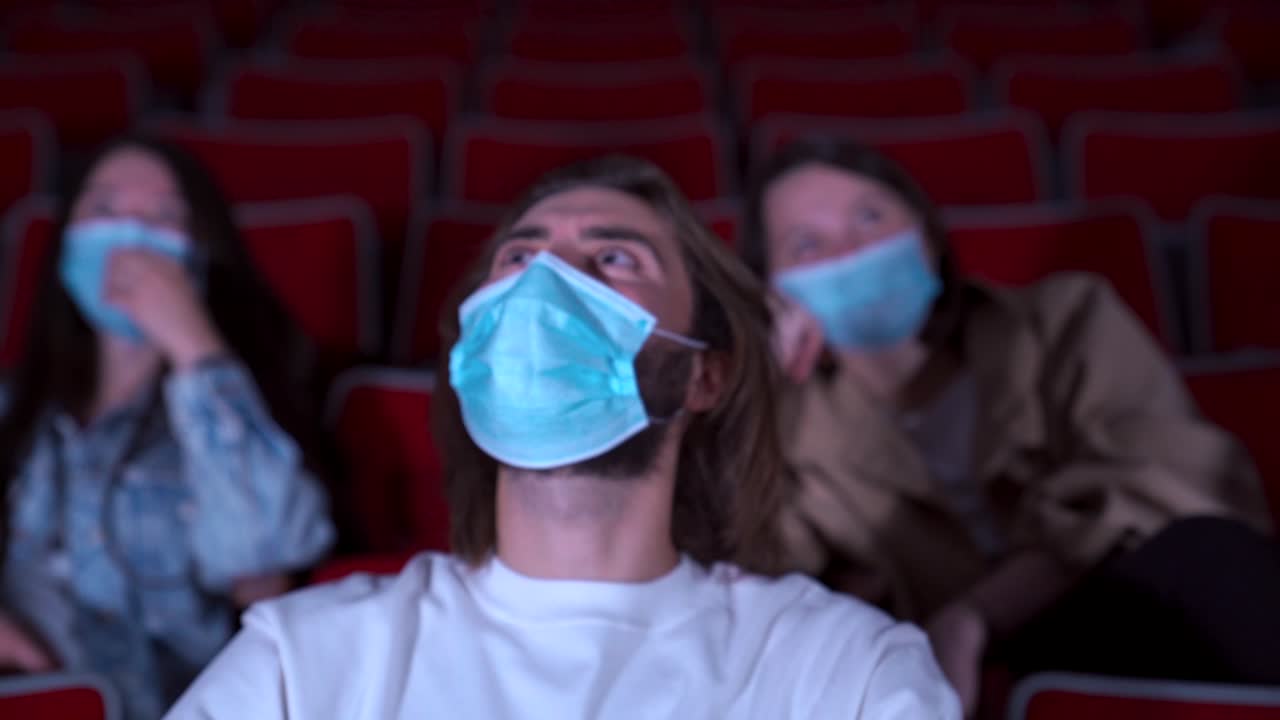 espectadores de cine con máscaras