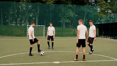 Gruppe-Junger-Fußballspieler,-Die-An-Einem-Sonnigen-Tag-Auf-Einem-Straßenfußballplatz-Trainieren-Und-Sich-Gegenseitig-Ball-Zuspielen-5