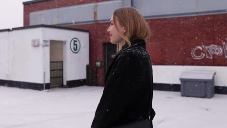 beautiful young blonde women being flirty while walking in a parking lot with a light snowfall in canada