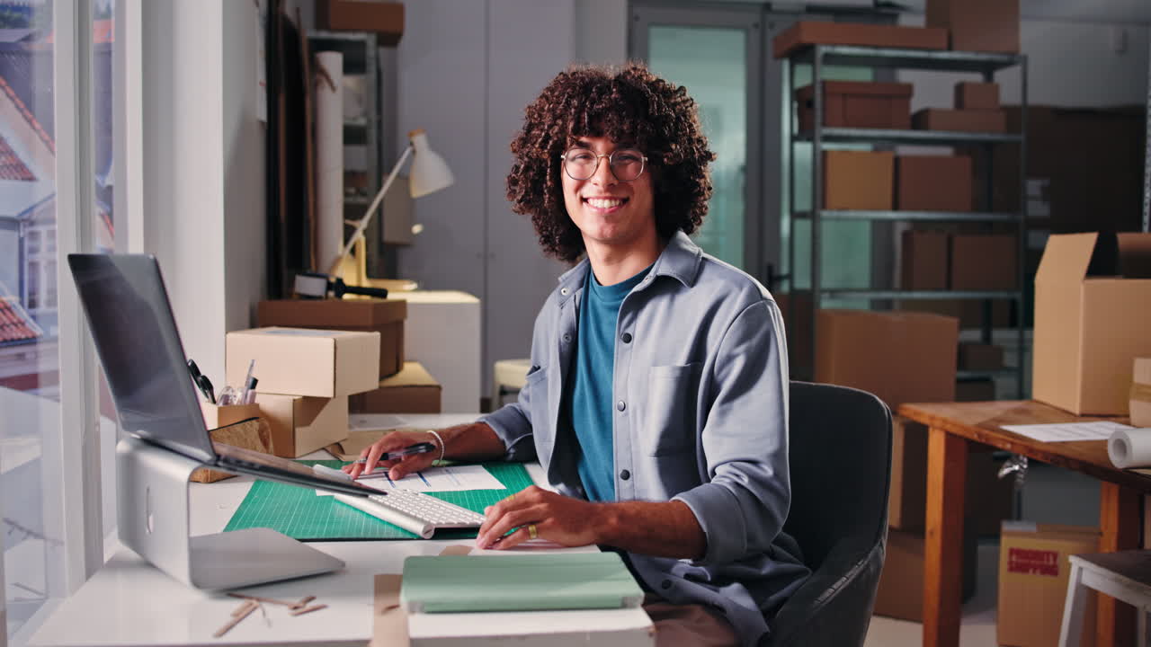 Entrepreneur souriant travaillant à son bureau dans un petit bureau d'entreprise.
