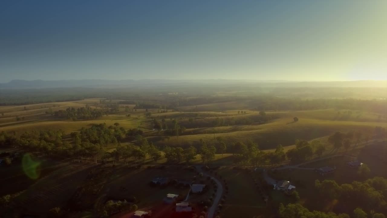 drones aéreos retrocediendo colinas al amanecer, en la región vinícola de hunter valley, australia