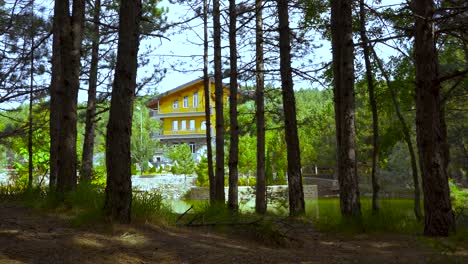 Hotel-En-Las-Montañas-Cerca-De-Un-Lago-Rodeado-De-Bosques-De-Pinos,-Destino-De-Vacaciones-Paradisíaco-En-Los-Alpes