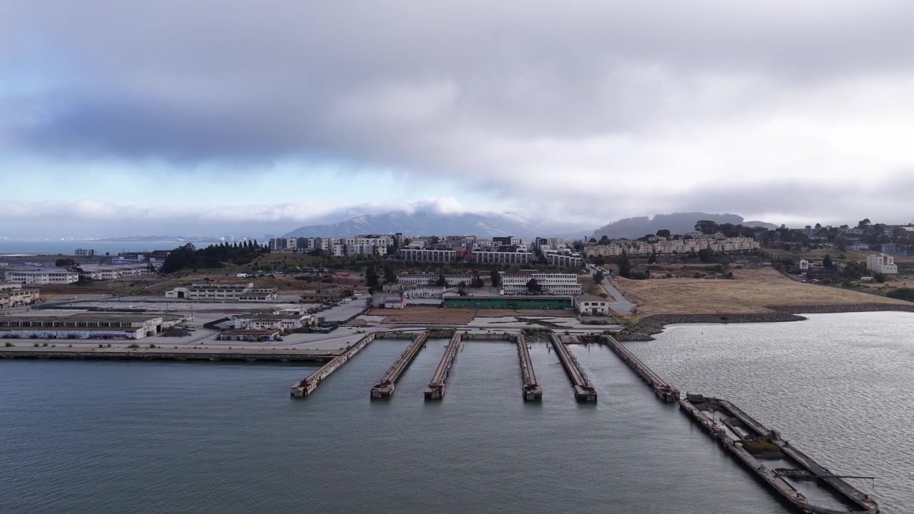 Vecchi moli di legno dividono le acque del porto vicino a un quartiere moderno nel quartiere di Bayview a San Francisco, California