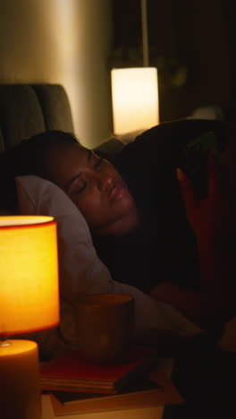 woman using phone in bed at night