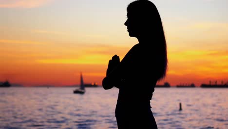 woman performing yoga on the beach