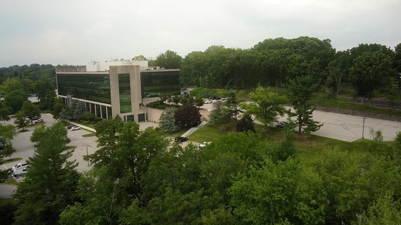 Plano aéreo de estabelecimento de um edifício de escritórios e estacionamento em King of Prussia, Pensilvânia, durante o verão.