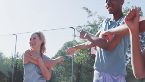 un equipo de baloncesto femenino feliz y diverso entrenando en una cancha soleada, en cámara lenta