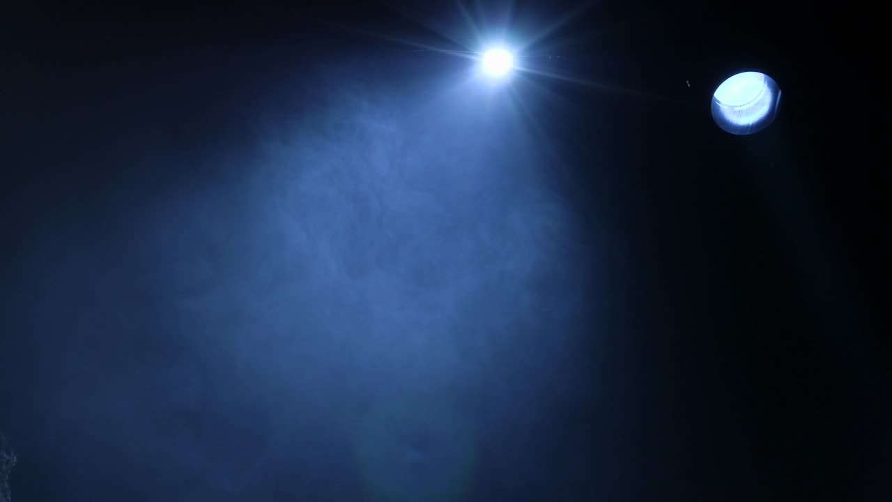 los rayos de los reflectores teatrales en el escenario durante la actuación. equipo de iluminación. el diseñador de la iluminación. humo teatral. el arte y la creatividad. metraje 4k