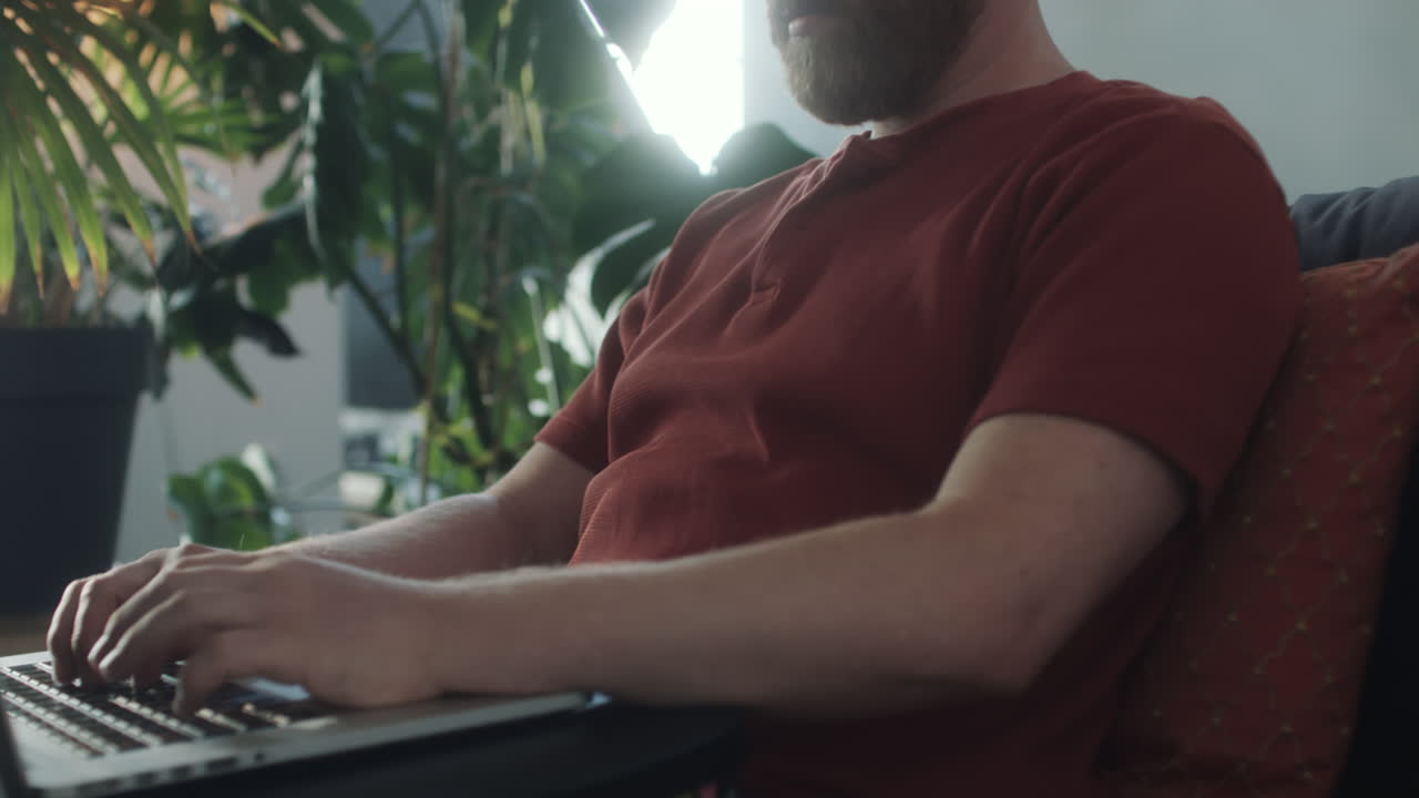 소파에 앉아 노트북에서 일하는 남자