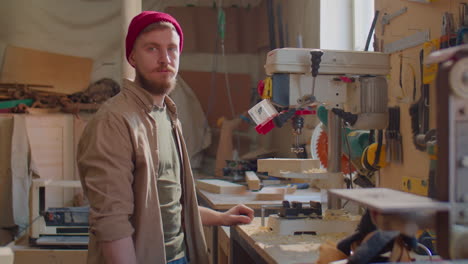 carpenter posing for camera in woodworking workshop