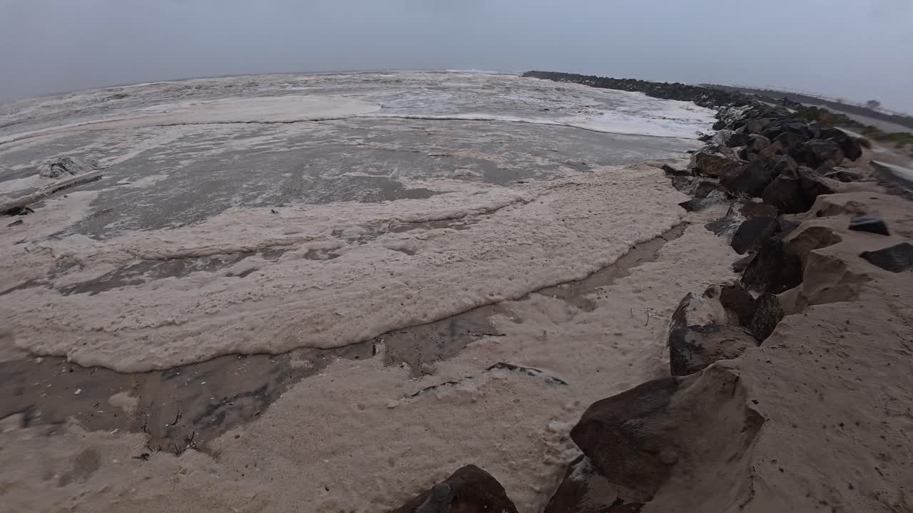 Duranbah Beach Covered With Ocean Foam On Stormy Weather. Tropical Cyclone Alfred In New South Wales, Australia. panning shot