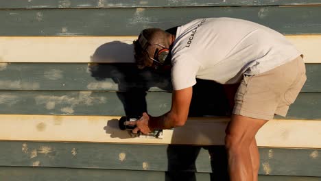 man repairing a beach hut in brighton