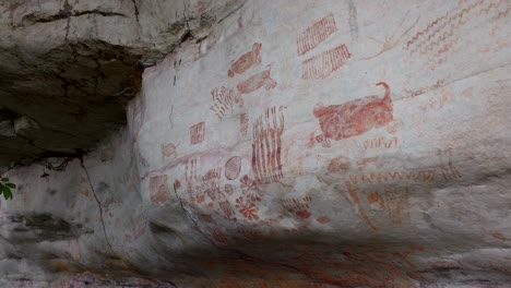 drone crane shot of a cliff showing ancient paintings
