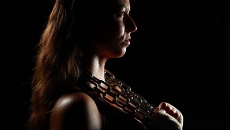 Muscular-woman-wearing-bandage-and-holding-chain-