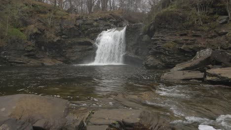 Toma-De-ángulo-Bajo-De-Las-Cataratas-De-Falloch-Que-Fluyen-Cerca-Del-Parque-Nacional-Loch-Lomond.