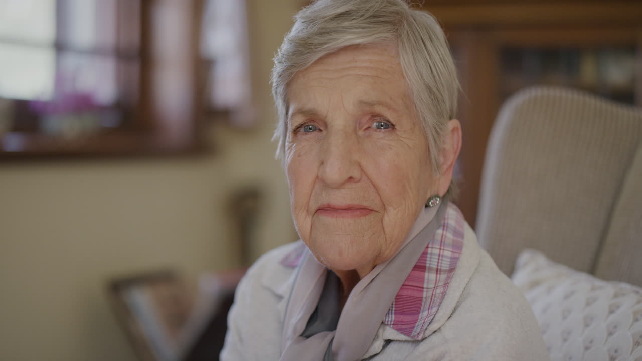 ritratto di una donna anziana che guarda pensosa contemplativa seduta nel soggiorno di una casa di riposo per anziani pensionato calmo rilassato anziano all'interno
