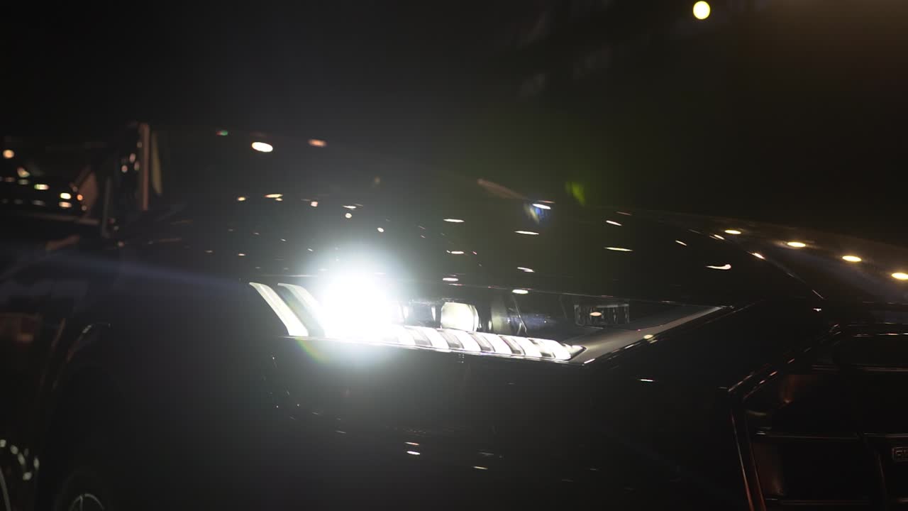 Close up of details of switched on headlights of anonymous prestigious luxury modern car. Concept of passion for driving cars and engines, car dealerships, used cars,luxury cars, auto dial