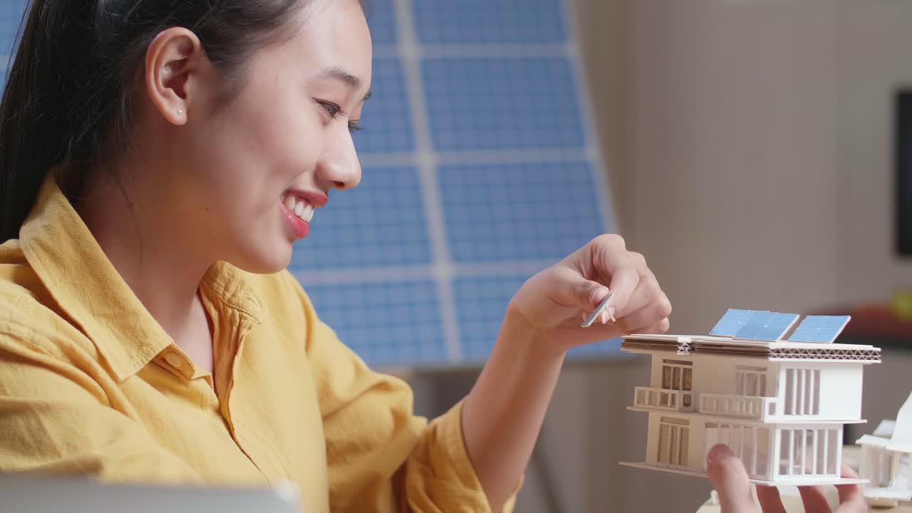 태양광 패널로 지속 가능한 주택 모델을 설계하는 여성