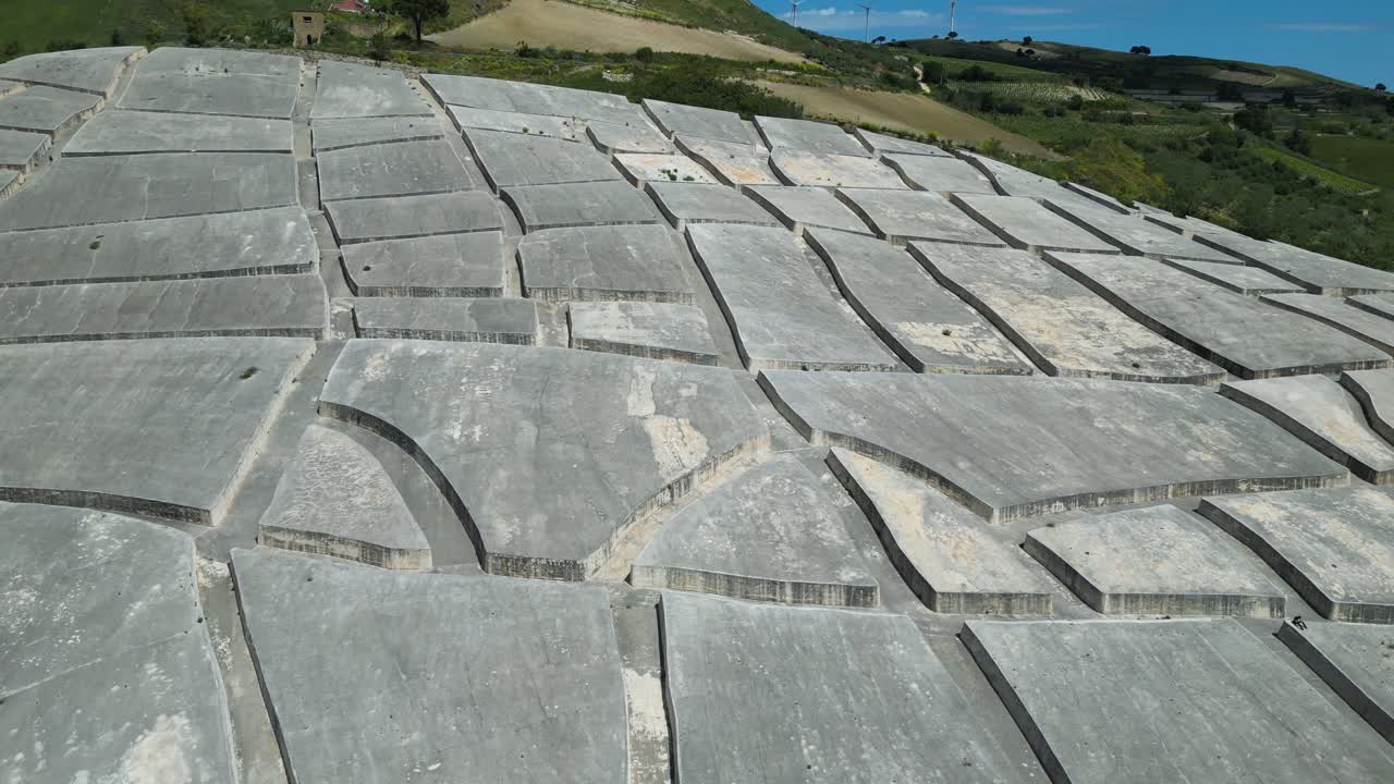 Aerial drone footage of the Cretto di Burri in Sicily: monumental white concrete labyrinth built over old Gibellina’s ruins. Perfect for art, history, and cultural documentary projects