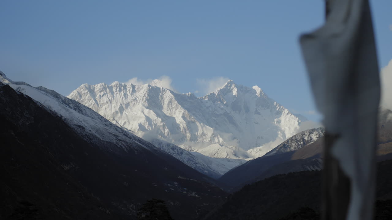 tiro deslizándose del monte lhotse con bandera de oración en primer plano