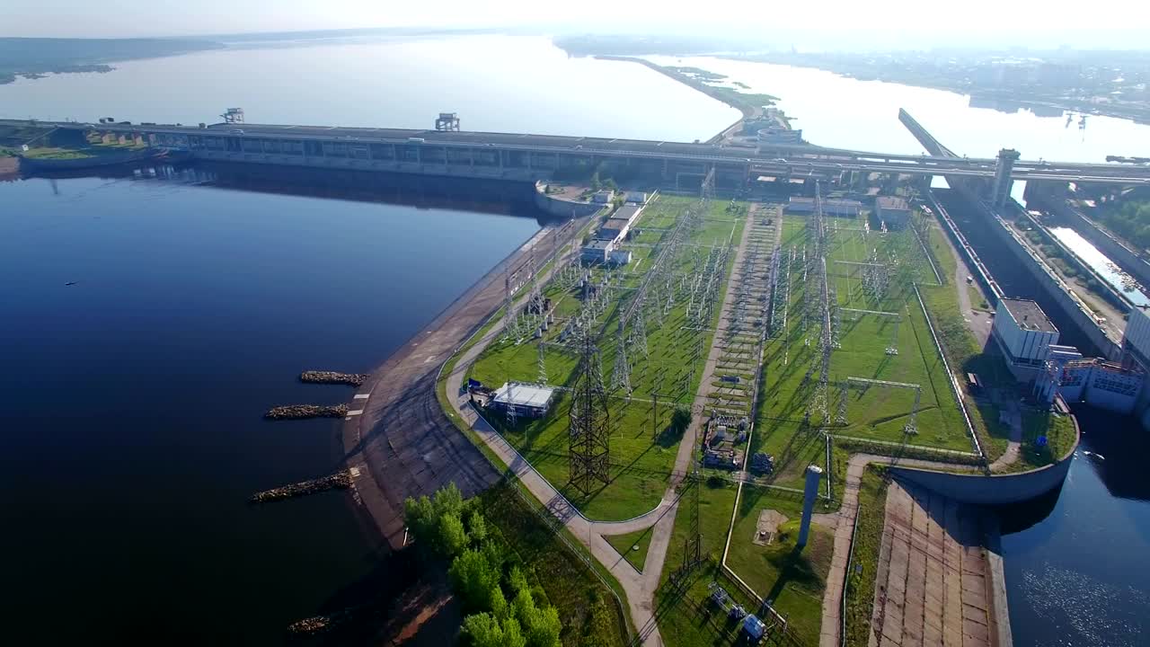 전체적인 공중 도 전망은 높은 전압 전력 탑, 수력 발전소 및 높은 기둥과 돼지 전압 분배 케이블을 가진 전기 서브 스테이션입니다.