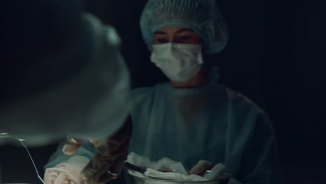 surgeon hands suturing patient closeup. team finish medical operation hospital.