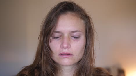 a close up portrait shot of a young woman with wounds and bruises, looks and stares directly into the camera and starts crying