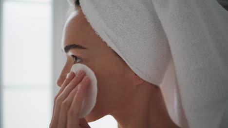 gorgeous woman cleaning face in bathroom closeup. girl removing impurities