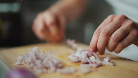 primer plano de cebolla cortada en cubos en una tabla de cortar de madera