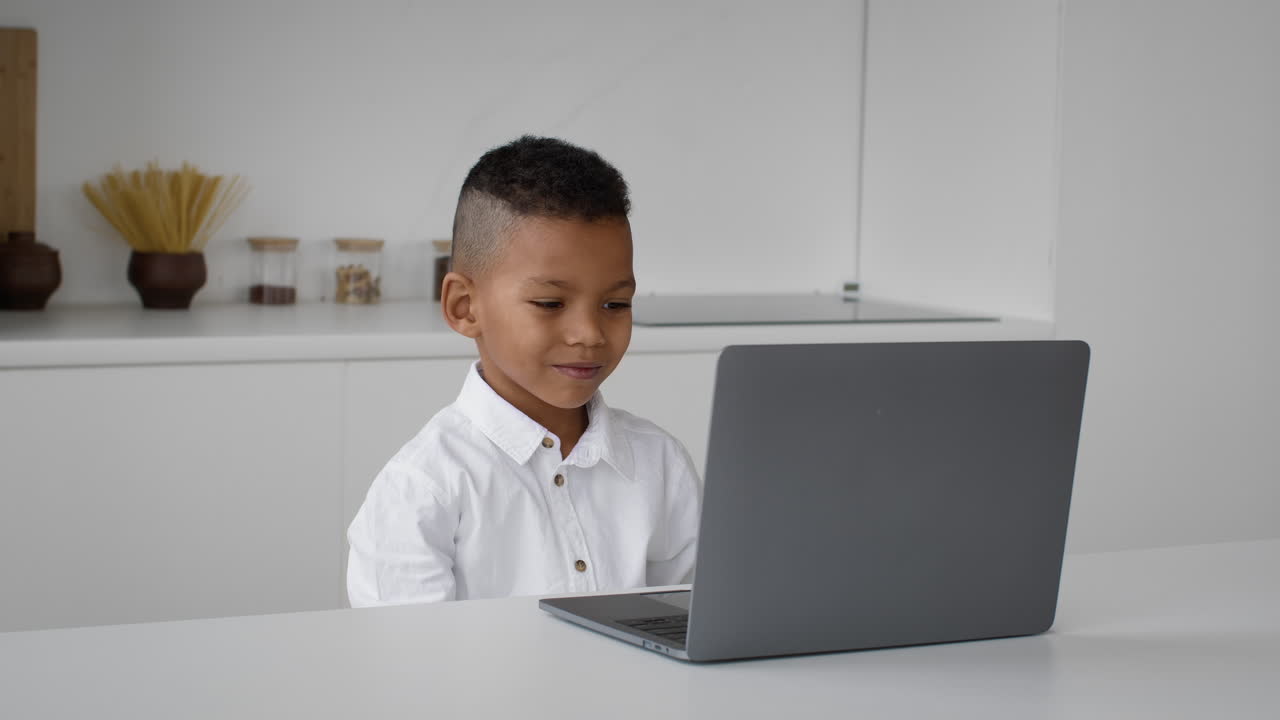 niño usando computadora portátil en la cocina