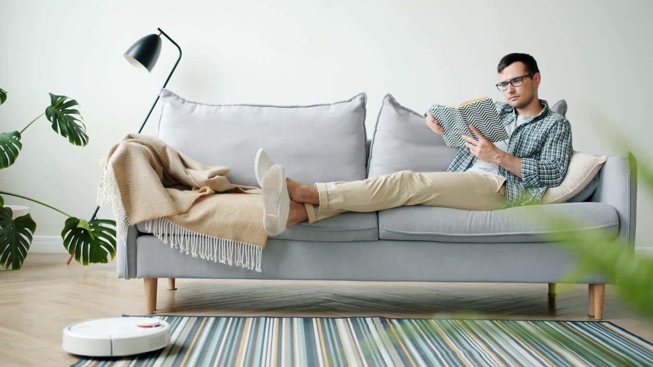 Man Relaxing on Couch Reading a Book