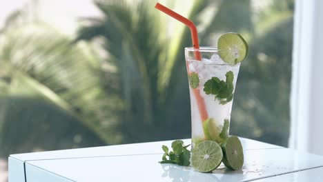 green-fresh-lime-halves-lie-on-wet-white-table-near-glass