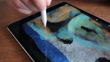 painting colorful forms on digital tablet with digital stylus pen, close up