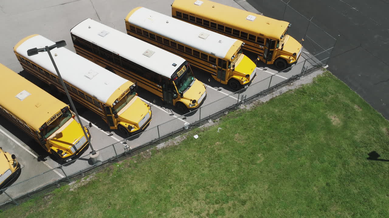 Row Of School Bus Used To Transport Students Parked In The Parking Lot