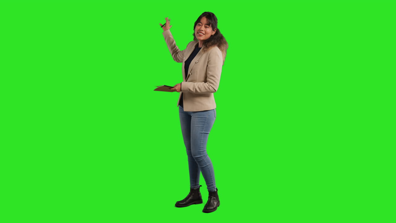 Full Length Studio Portrait Of Female Teacher With Notebook Talking To Class Standing Against Green Screen 3