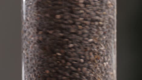 chia seeds blending and rotating in water close-up macro black background. dry healthy ingredient. healthy superfood rich in omega 3 fatty acids. salvia hispanica