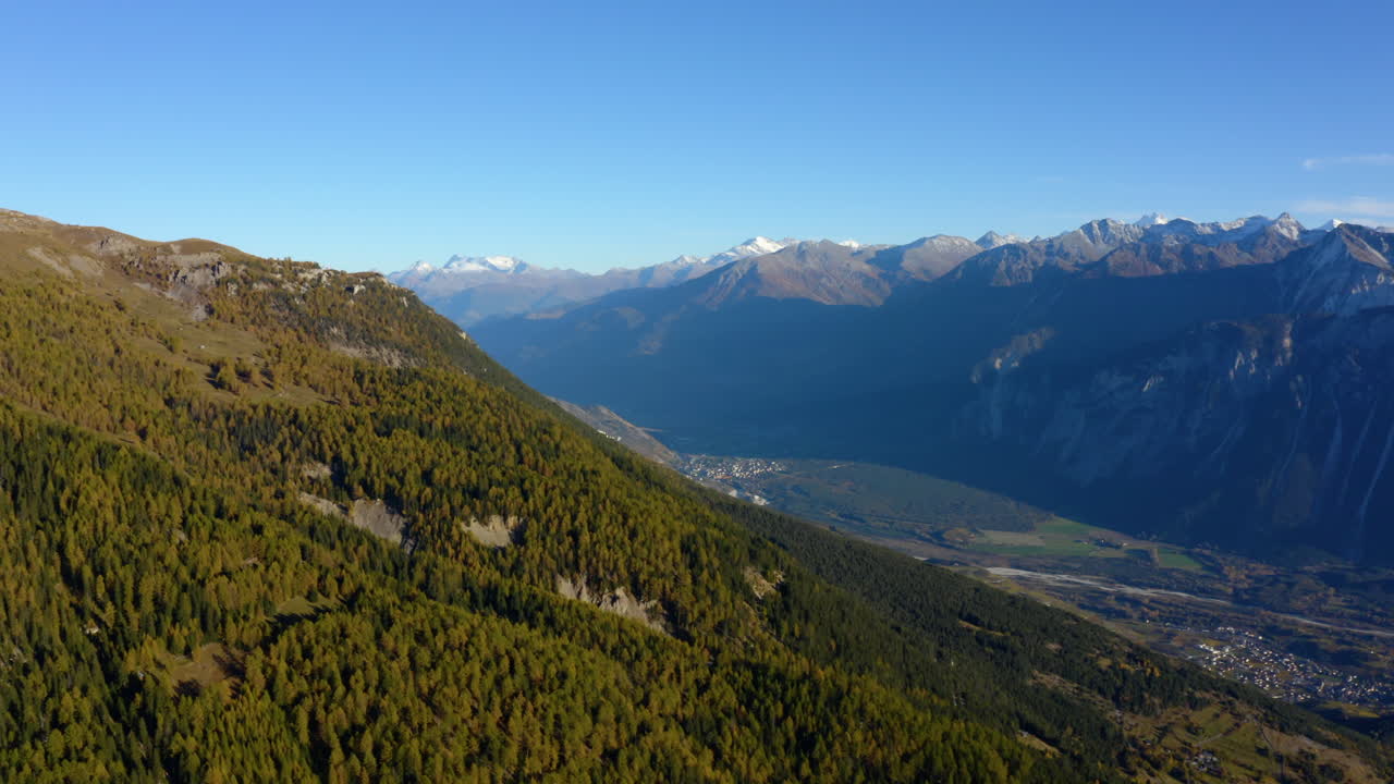 Veduta aerea del Comune di Crans-Montana nel Canton Vallese in Svizzera, con la Valle del Rodano e il villaggio di Susten sullo sfondo, durante l'autunno.