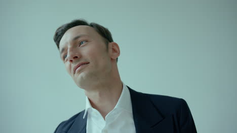 Close-up-of-face-of-suited-caucasian-man-turning-head-and-smiling